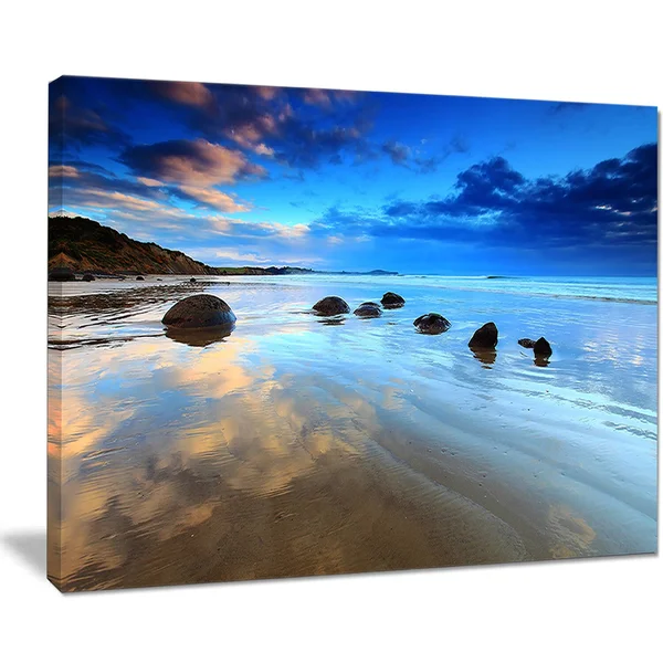 Design Art 'Cloudy Sky Over Moeraki Boulders' Photographic Print on Wrapped Canvas, Size: 16 inch H x 32 inch W x 1 inch D, Blue